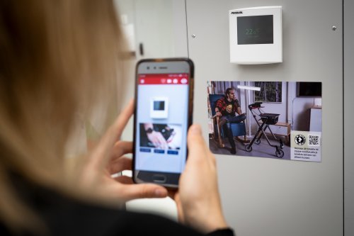 kotikulman vierailija osoittaa älypuhelimella ar-kierroksen qr-koodia