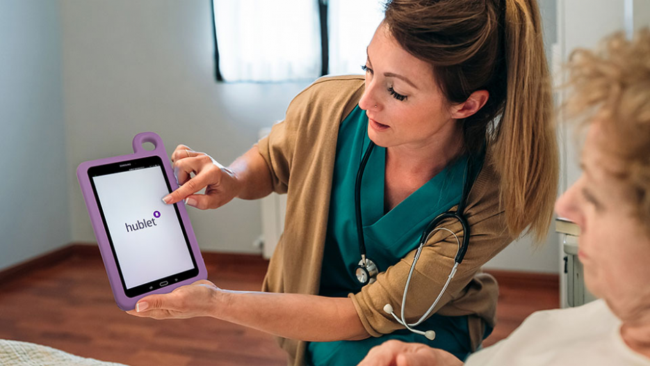 Female doctor showing tablet to female senior patient